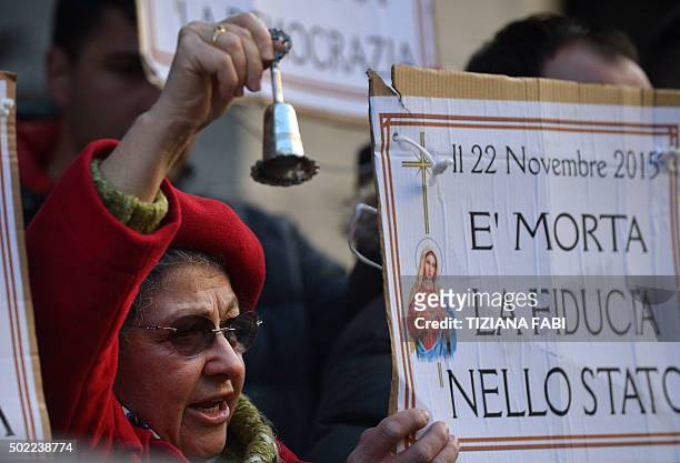 Woman holds a sign reading 'is dead, confidence in the state' during a protest against the collapse of four Italian banks in central Rome on December...