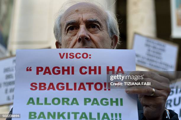 Participant holds a sign reading 'those pay who did wrong, so Bankitaliahas to pay' during a protest against the collapse of four Italian banks in...