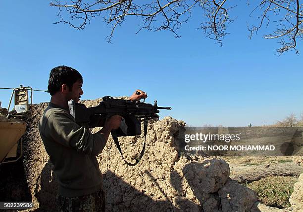 An Afghan National Army soldier keeps watch during an ongoing battle with Taliban militants in the Nad Ali district of Helmand on December 22, 2015....
