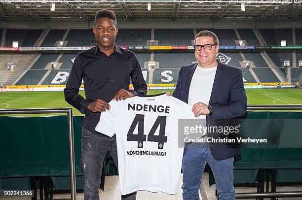 Tsiy William Ndenge and Director of Sport Max Eberl of Borussia Moenchengladbach pose with Ndenges Shirt after signing a new contract for Borussia...