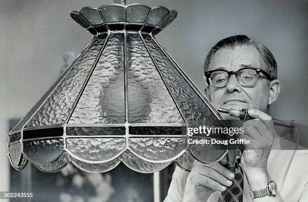 Gerhardt Tehiessen; of Kitchener; puts the finishing touches to the reproduction of a Tiffany lamp he made for the sale. He spent 40 hours making...