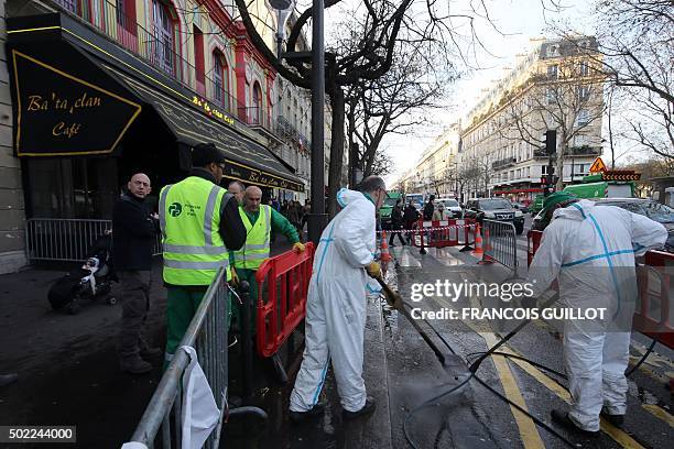 City workers clean the sidewalk and the street in front of the Bataclan concert hall in Paris on December 22 after the sidewalk in front of the venue...