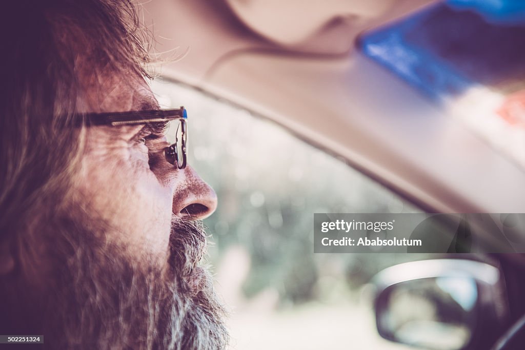 Close-up of Senior Man with Glasses and Beard Driving