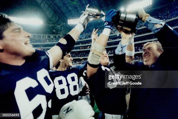 Jubilant Argonaut co-owner John Candy hoists the Eastern Division cup with Dan Ferrone, left, Paul Masotti and Don Moen yesterday after the Argos...