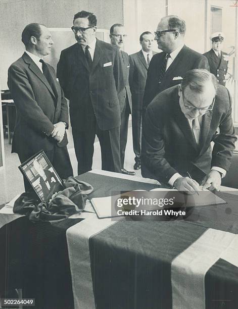 Board signs churchill book. Controller Herbert Orliffe signs book of condolence which was opened at the British Government Office on Univesity Ave....