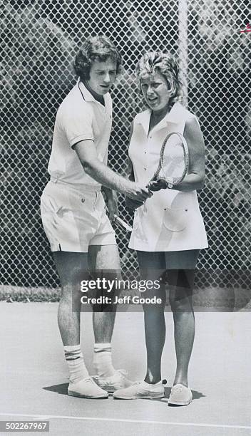 Tip from the Top: Mike Belkin, Canada's number one tennis star, instructs Mrs. Robert Whitty at summer tennis school on York University's Glendon...