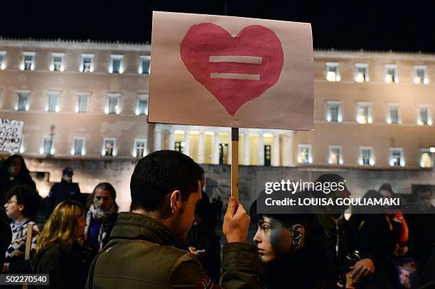 Man holds a placard picturing an equality sign inside a heart during a demonstration of gay rights activists and members of the Athens LGBT community...