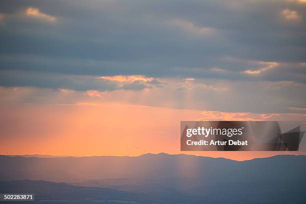 Magic sunset sky with golden sunbeam through the clouds and landscape.