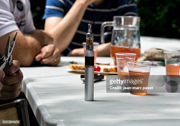 Electronic cigarette on a table Electronic cigarette on a table during a moment of conviviality with friends who drink a aperitif outdoors