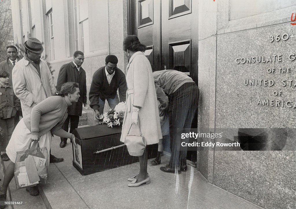 Pro football player Ted Watkins (centre; in cardigan and glasses) helps other members of Afro-Americ