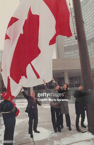 Mayor Art Eggleton; right; hoists the flag on its 25th birthday yesterday together with; from left; a civic worker and Toronto councillors Bill...