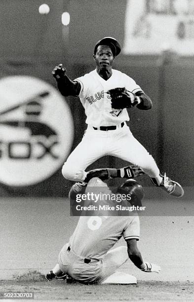 Double trouble: Blue Jays shortstop Tony Fernandez leaps to avoid a sliding Kansas City Royals baserunner Willie Wilson and complete a double play...