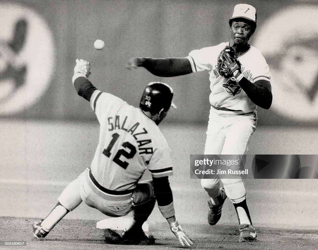 Turning two: Jays shortstop Tony Fernandez zips the ball past a sliding Luis Salazar on the way to a
