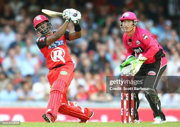 Dwayne Bravo of the Renegades hits a six as wicketkeeper Brad Haddin of the Sixers looks on during the Big Bash League match between the Melbourne...