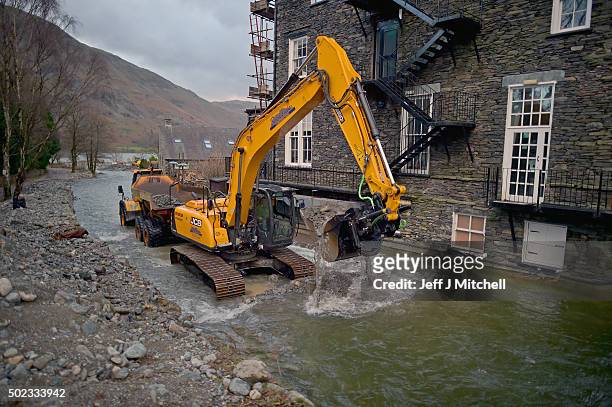 Workmen clear silt from the river on December 23, 2015 in Glenridding, England. It is feared that rain and winds of up to 70mph could continue to...