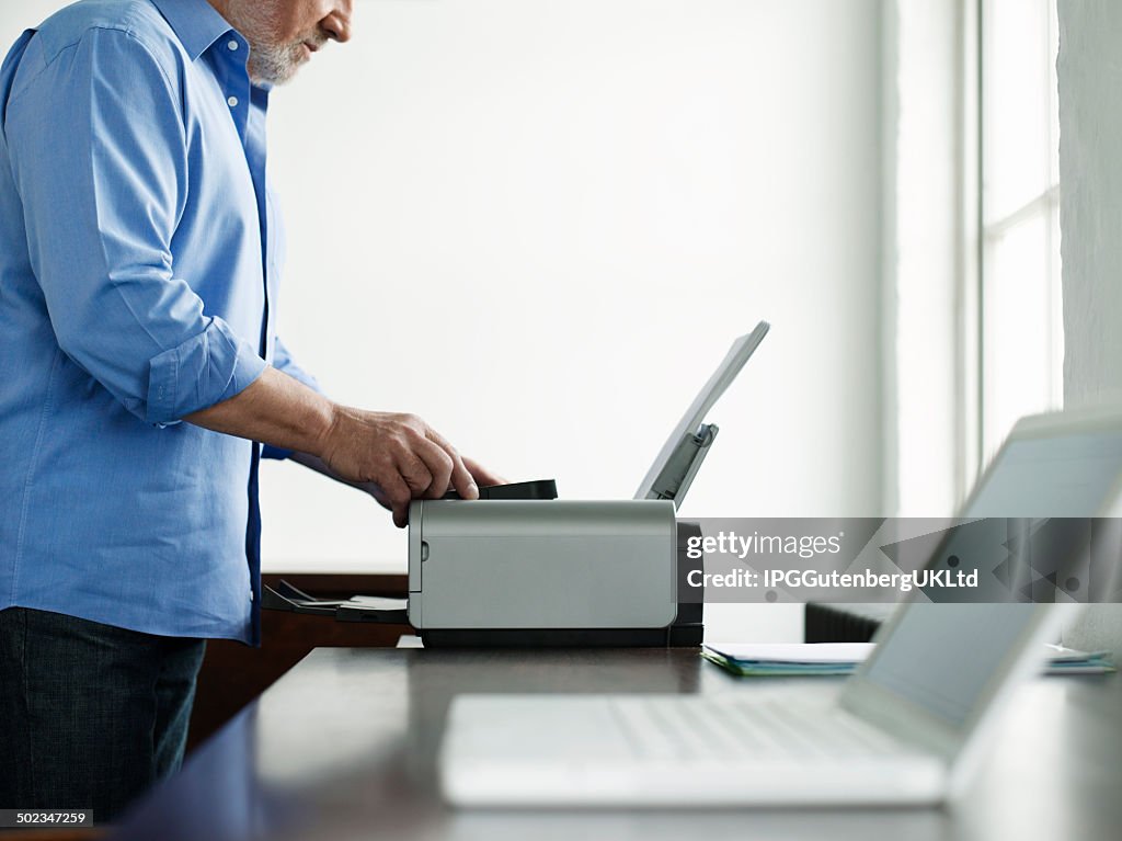 Mann mit Drucker im Arbeitszimmer Tisch im Haus