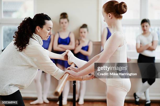 ballet teacher helping dancer in dance studio - dancers exercising teacher stockfoto's en -beelden