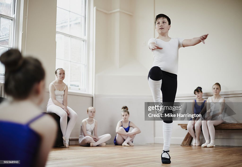 Male dancer performing pirouette in front of class