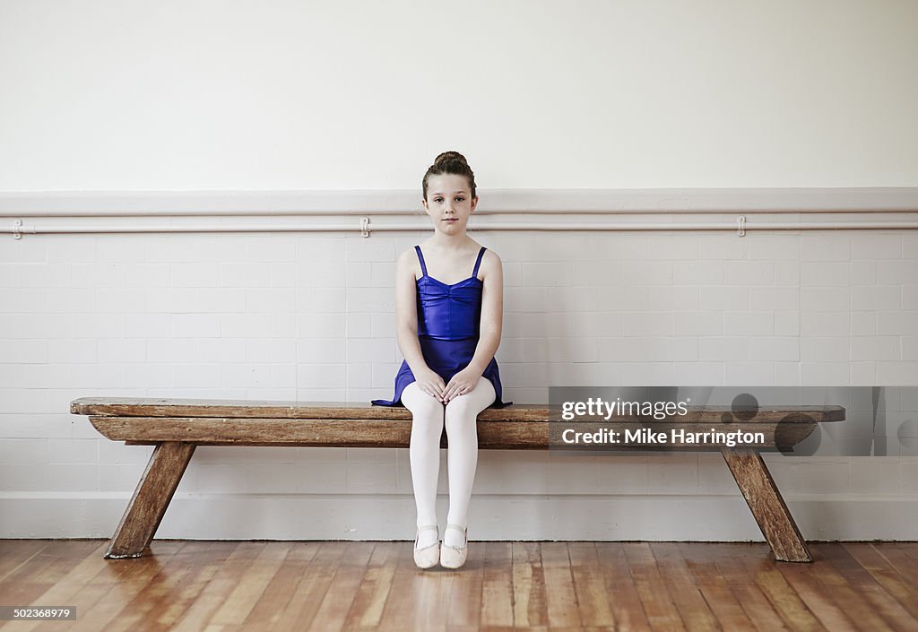 Young female ballet dancer on bench.
