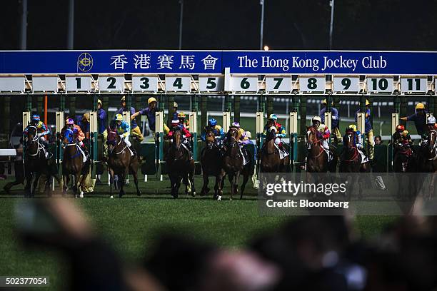 Horses leave the starting gate during a race at the Hong Kong Jockey Club's Happy Valley racecourse in Hong Kong, China, on Wednesday, Dec. 23, 2015....