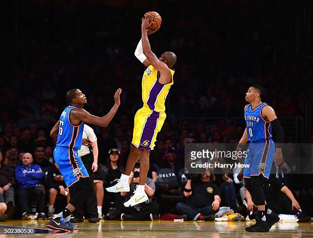 Kobe Bryant of the Los Angeles Lakers shoots a jumper between Kevin Durant and Russell Westbrook of the Oklahoma City Thunder during the first half...