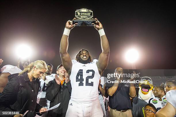 Defensive end Nardo Govan of the Georgia Southern Eagles hold up the Most Valuable Defensive trophy after defeating the Bowling Green Falcons on...