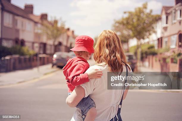 mother and son looking down suburban road - madre soltera fotografías e imágenes de stock