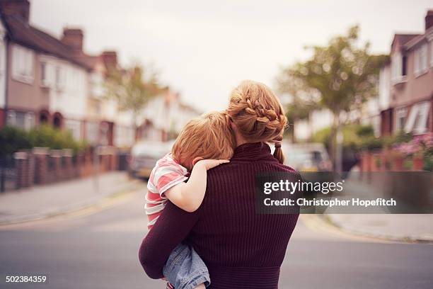 young boy resting on mother's shoulder - eén ouder stockfoto's en -beelden