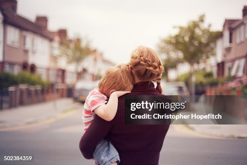 Young boy resting on mother's shoulder Young boy resting on mother's shoulder