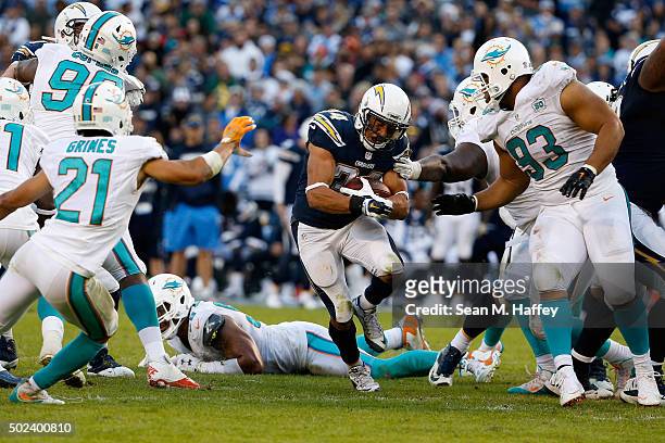 Donald Brown of the San Diego Chargers splits the defense of Ndamukong Suh of the Miami Dolphins, Brent Grimes of the Miami Dolphins, and Quinton...