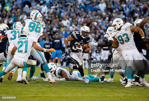 Donald Brown of the San Diego Chargers splits the defense of Ndamukong Suh of the Miami Dolphins, Brent Grimes of the Miami Dolphins, and Quinton...