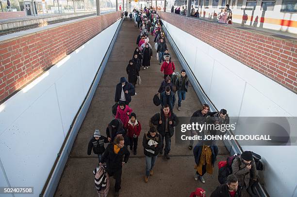 Asylum-seekers walk on the platform after getting off a train coming from Freilassing and transporting some 200 asylum-seekers as they arrive at the...