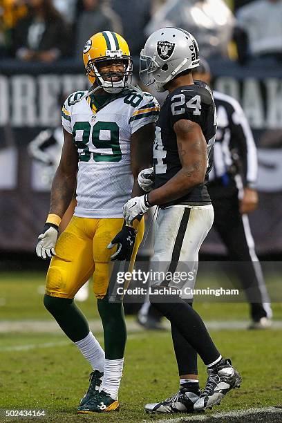 Wide receiver James Jones of the Green Bay Packers talks to safety Charles Woodson of the Oakland Raiders in the fourth quarter at O.co Coliseum on...