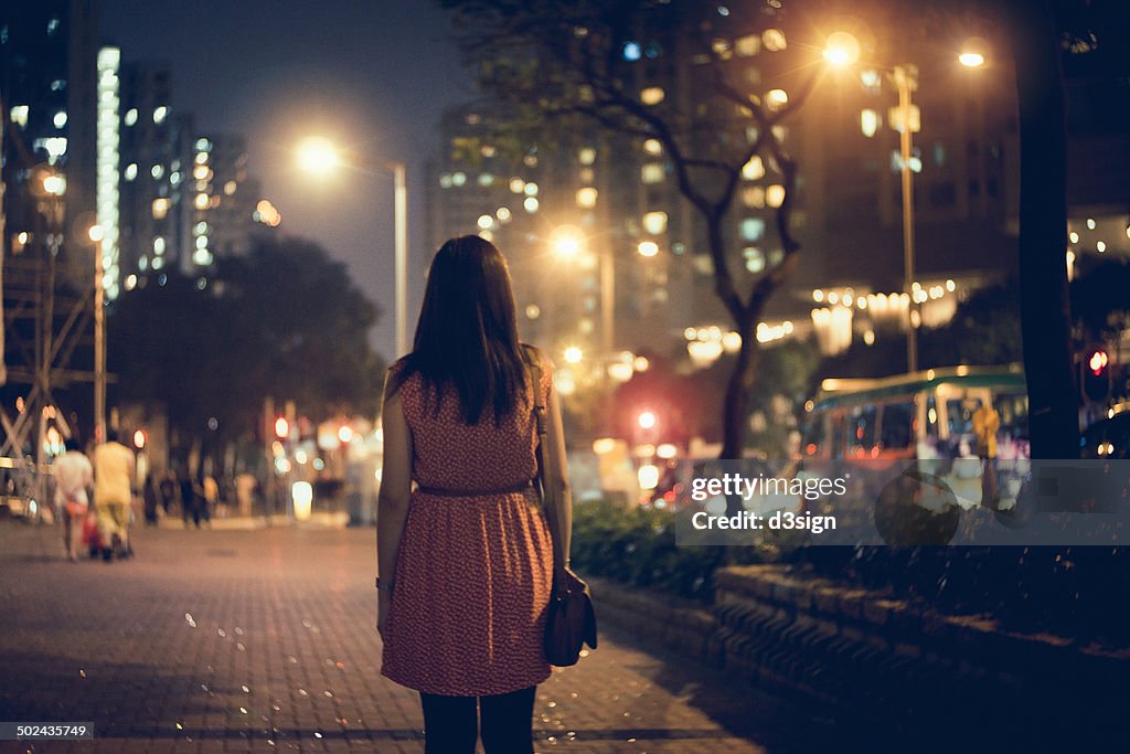 Lonely  woman walking along the city street