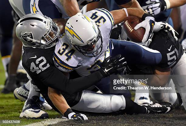 Donald Brown of the San Diego Chargers scores on a one yard run and gets tackled in the endzone by Larry Asante of the Oakland Raiders in the first...