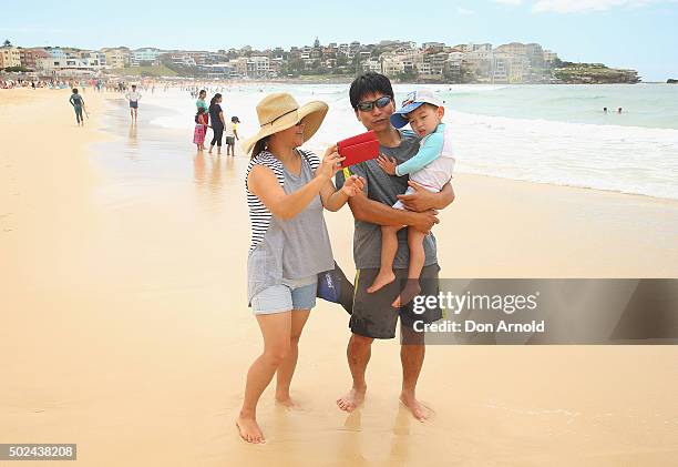 The Jin family, from Seoul, South Korea, take selfies at Bondi Beach on December 25, 2015 in Sydney, Australia. Bondi Beach is a popular tourist...