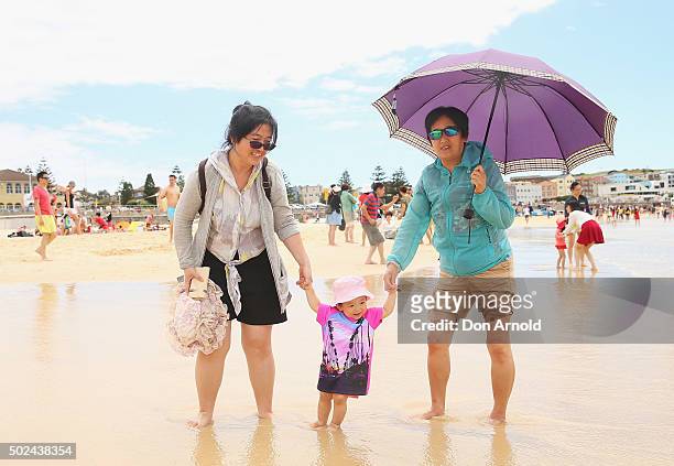 A family walks along the shore line at Bondi Beach on December 25, 2015 in Sydney, Australia. Bondi Beach is a popular tourist destination on...