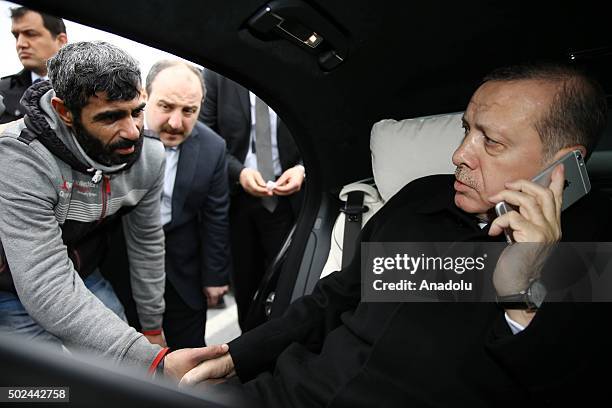 Turkish President Recep Tayyip Erdogan shakes hands with a person who was about to attempt suicide on the Bosporus bridge after Erdogan made him give...