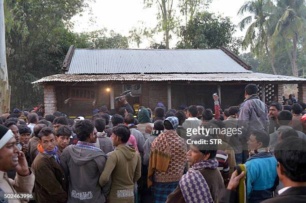 Onlookers gather following a suicide bomb blast at a Ahmadiyya mosque during Friday prayers in Rajshahi, some 250 kms from Dhaka on December 25,...