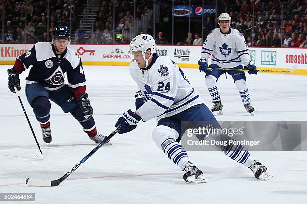 Peter Holland of the Toronto Maple Leafs controls the puck against Alex Tanguay of the Colorado Avalanche at Pepsi Center on December 21, 2015 in...