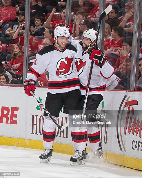 David Schlemko of the New Jersey Devils celebrates his first period goal with teammate Jiri Tlusty during an NHL game against the Detroit Red Wings...