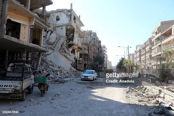 Syrians walk on the debris of buildings after Russian army carried out airstrike to eastern Ghouta in Damascus, Syria on December 25, 2015.