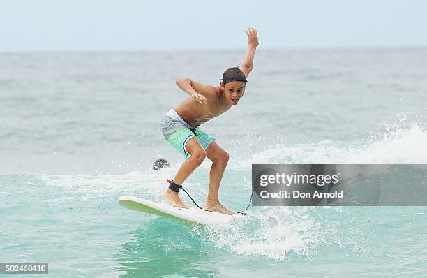 Young boy rides a wave at Bondi Beach on December 25, 2015 in Sydney, Australia. Bondi Beach is a popular tourist destination on Christmas Day.