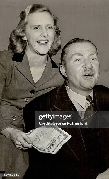 Charles W. A. Scott and his Canadian - born wife discussing the victory bond they'll buy when the fourth loan campaign begins monday. For six month...