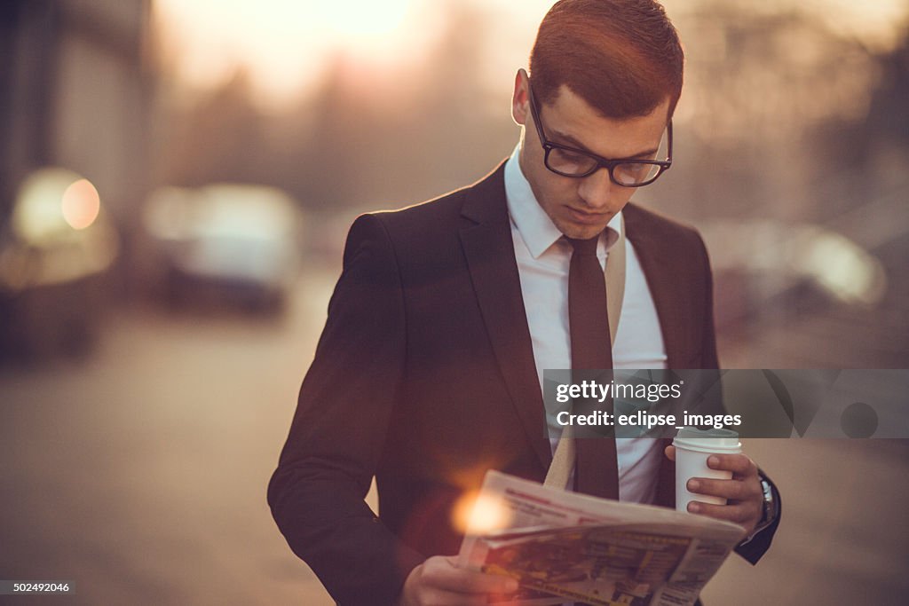 Business-Mann mit Kaffee und Tageszeitung