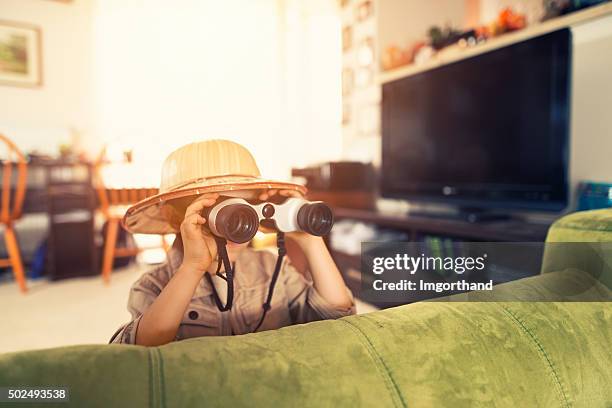 little boy with binoculars exploring living room - imagination kids stock pictures, royalty-free photos & images