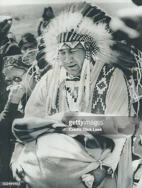 Burying their son: Nelson Small Legs Sr. And his wife; Florence; stand in anguish before the grave of their son; Nelson Jr.; holding a Hudson Bay...