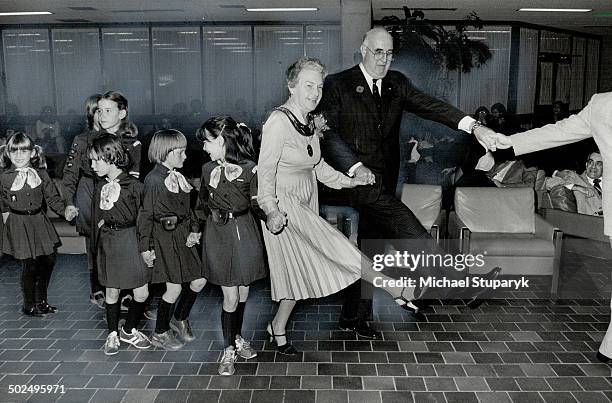 Ceremonial dance. Mayor Hazel McCallion and Lieutenant-Governor John Aird join with Brownies in Indian dance following the opening of exhibition of...