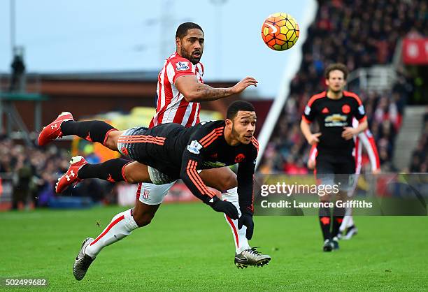 Memphis Depay of Manchester United heads the ball under pressure from Glen Johnson of Stoke City during the Barclays Premier League match between...