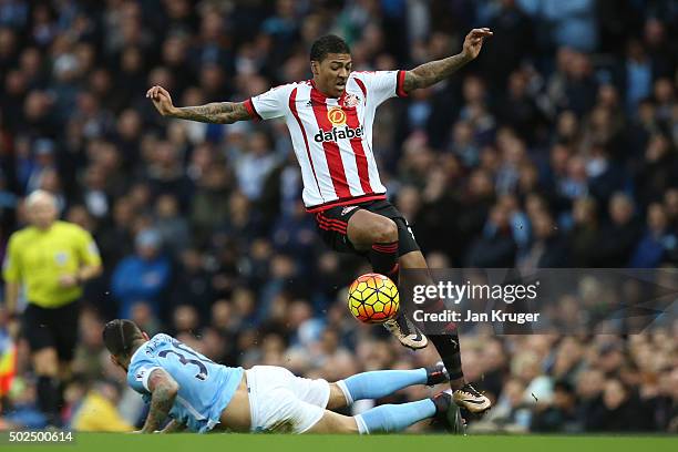 Patrick Van Aanholt of Sunderland is tackled by Nicolas Otamendi of Manchester City during the Barclays Premier League match between Manchester City...